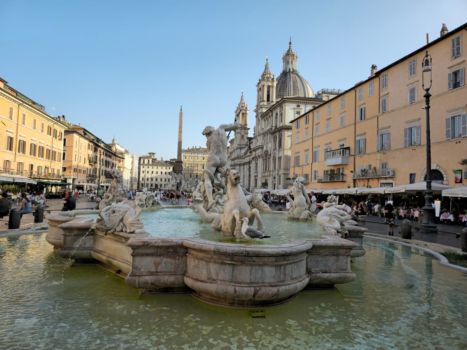 The Fountain of the Four Rivers and obelisk in Piazza Navona under a dramatic winter sky.