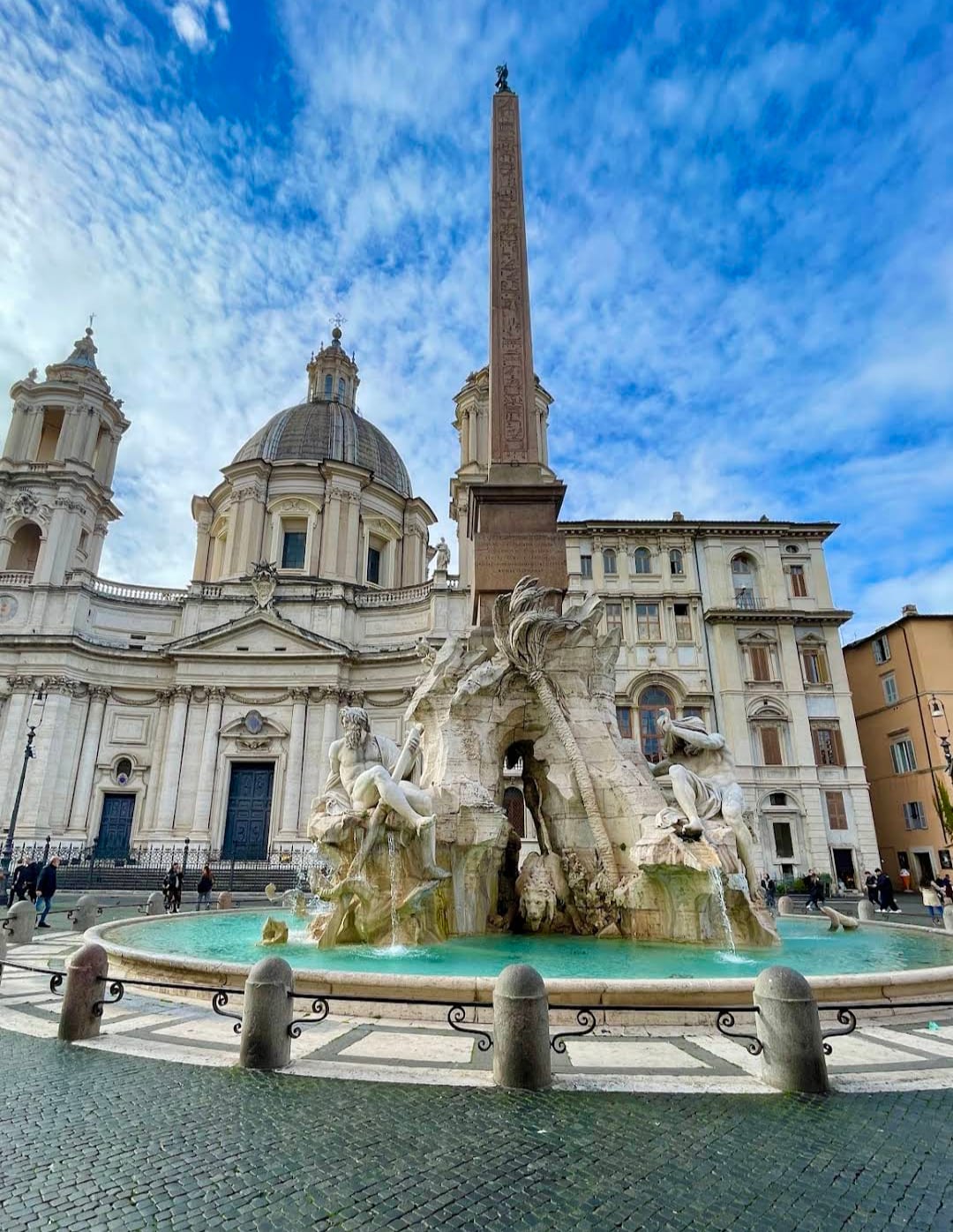The Fountain of the Four Rivers and obelisk in Piazza Navona under a dramatic winter sky.
