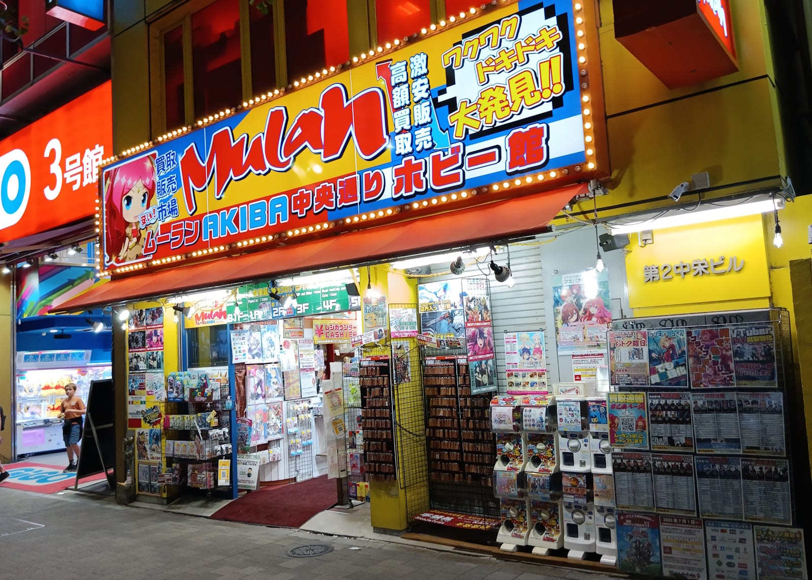A multi-floor Akihabara shop stacked with bright signs and figures.