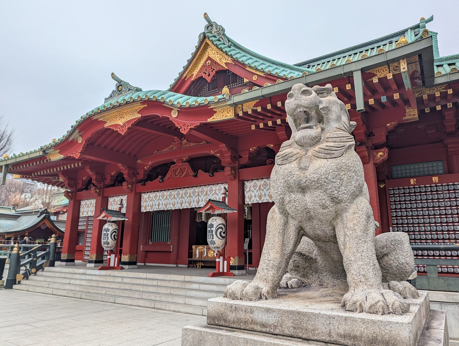 Kanda Myojin's vermilion main hall and bronze guardian lion-dog.