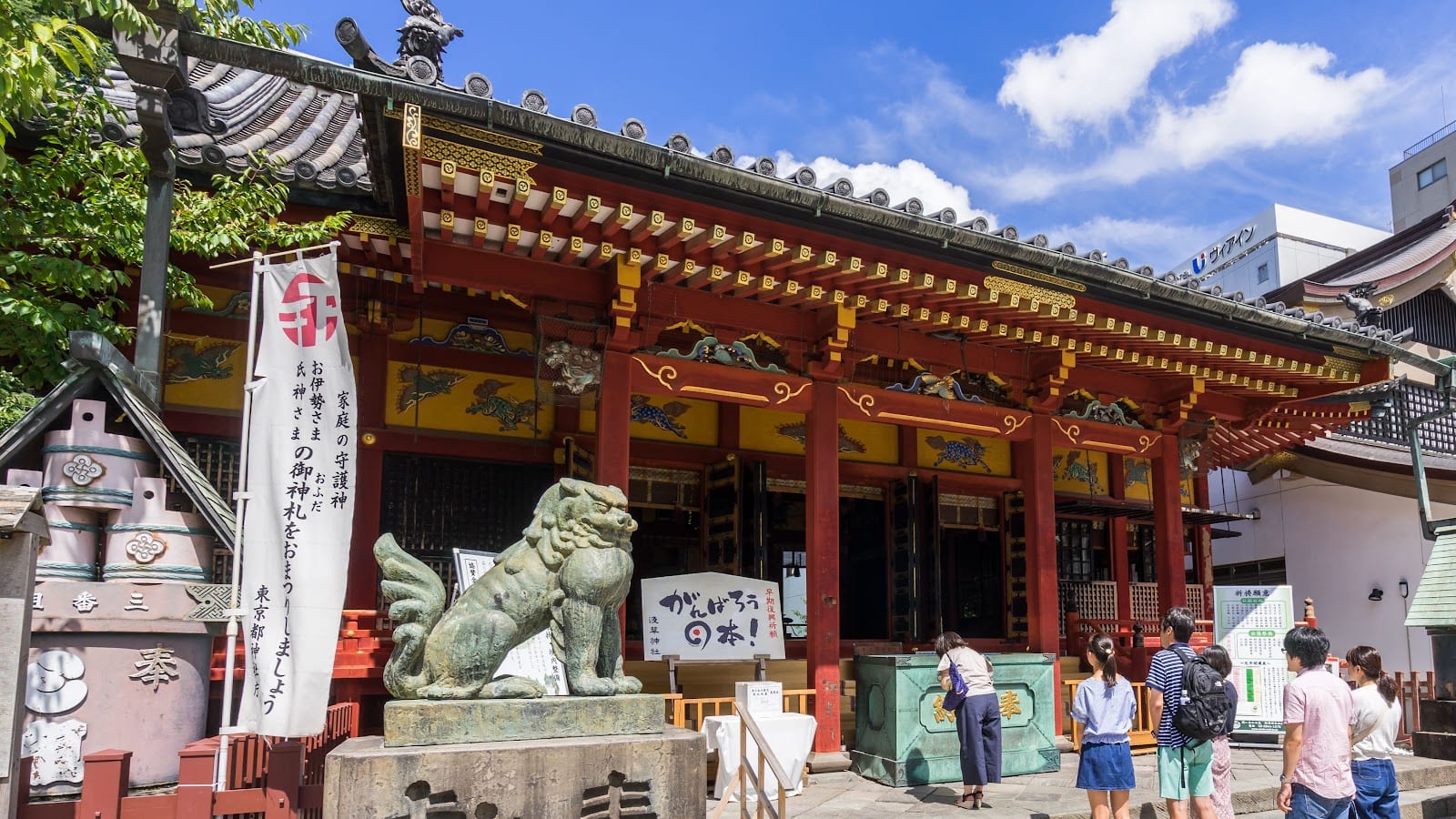 The ornate main hall of Asakusa Shrine and its guardian lion-dog.