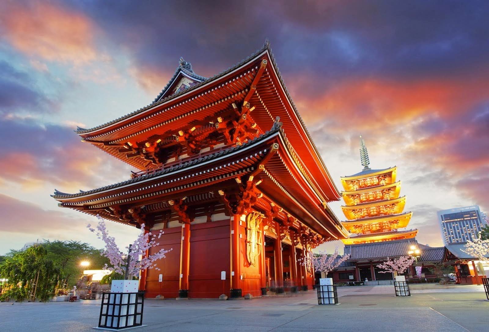 Senso-ji's Hozomon gate and five-story pagoda lit at sunset.