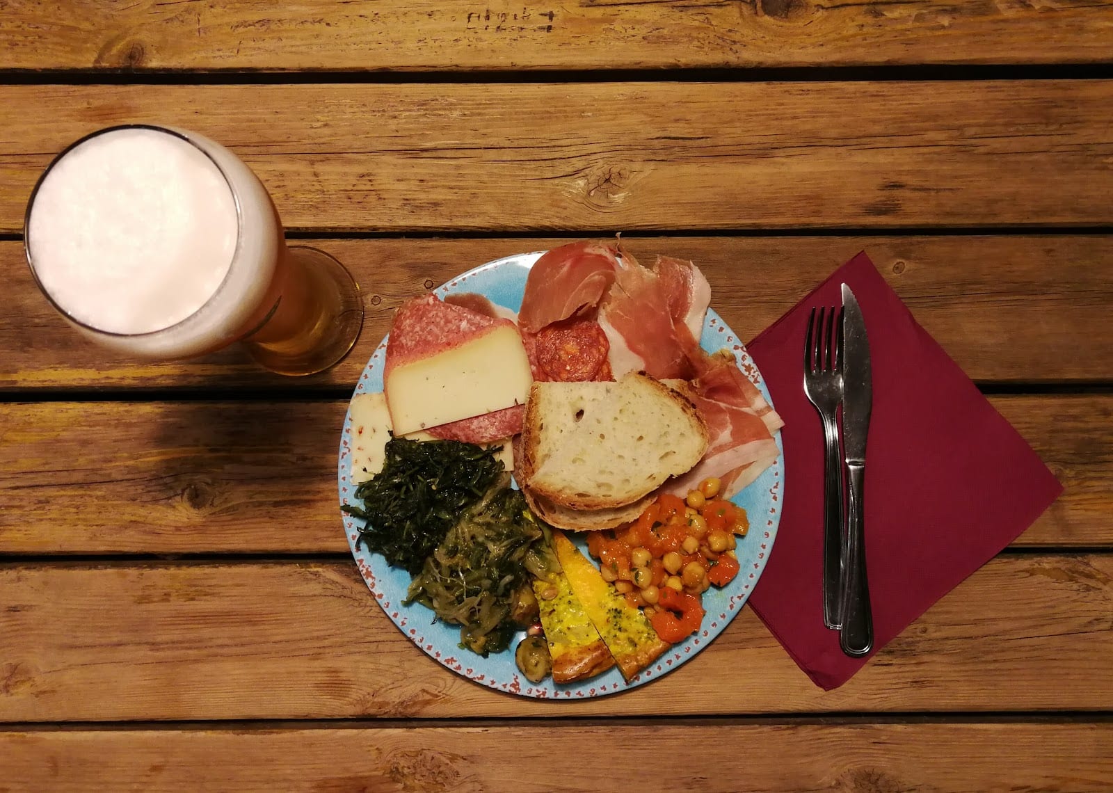 An aperitivo plate of cheese and cured meats with a beer at L'Oasi della Birra.
