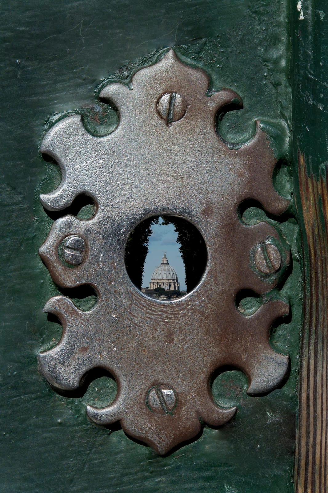The dome of St Peter's framed through the Knights of Malta keyhole down an avenue of cypresses.