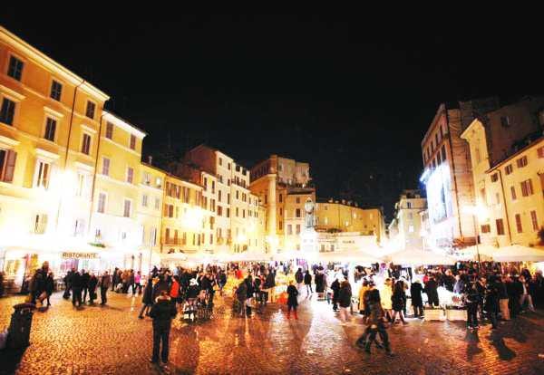 The bar and cafe crowd filling Campo de' Fiori after dark.