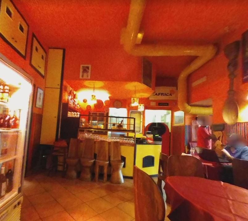 The warm red-toned interior of the historic Africa Restaurant in Rome.