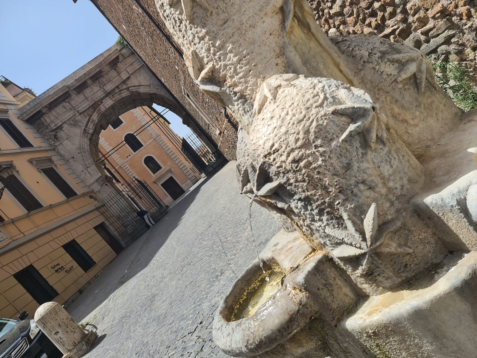 The Arch of Gallienus seen down a sloping Esquilino street.