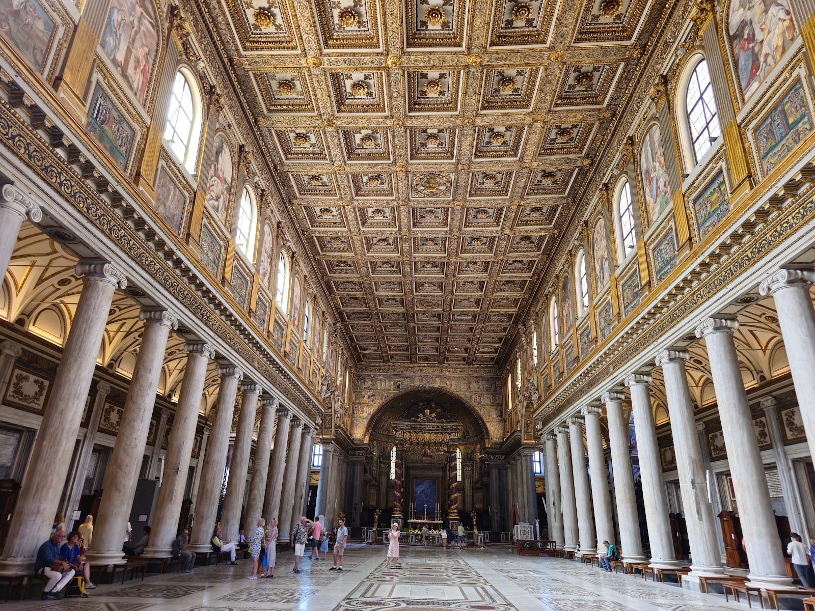 The gilded coffered ceiling and ancient columns of the nave of Santa Maria Maggiore.