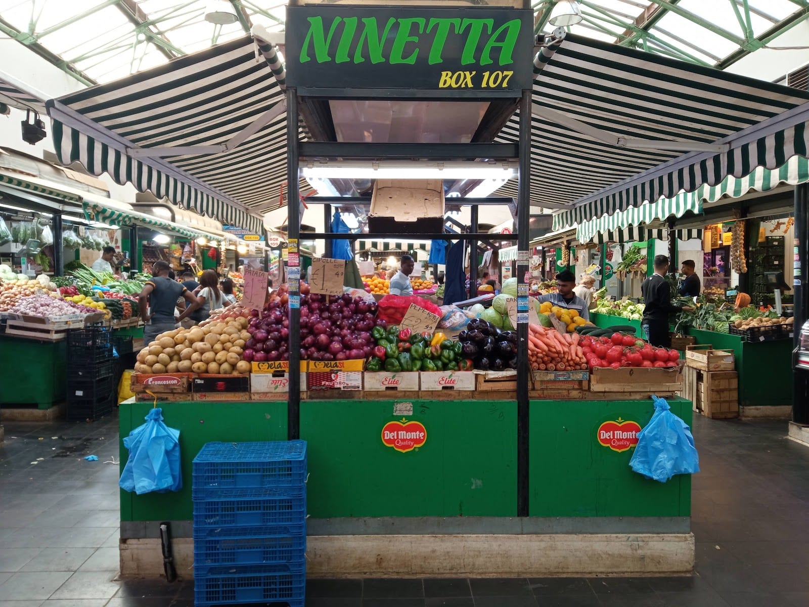 A colorful fruit and vegetable stall inside the Nuovo Mercato Esquilino.