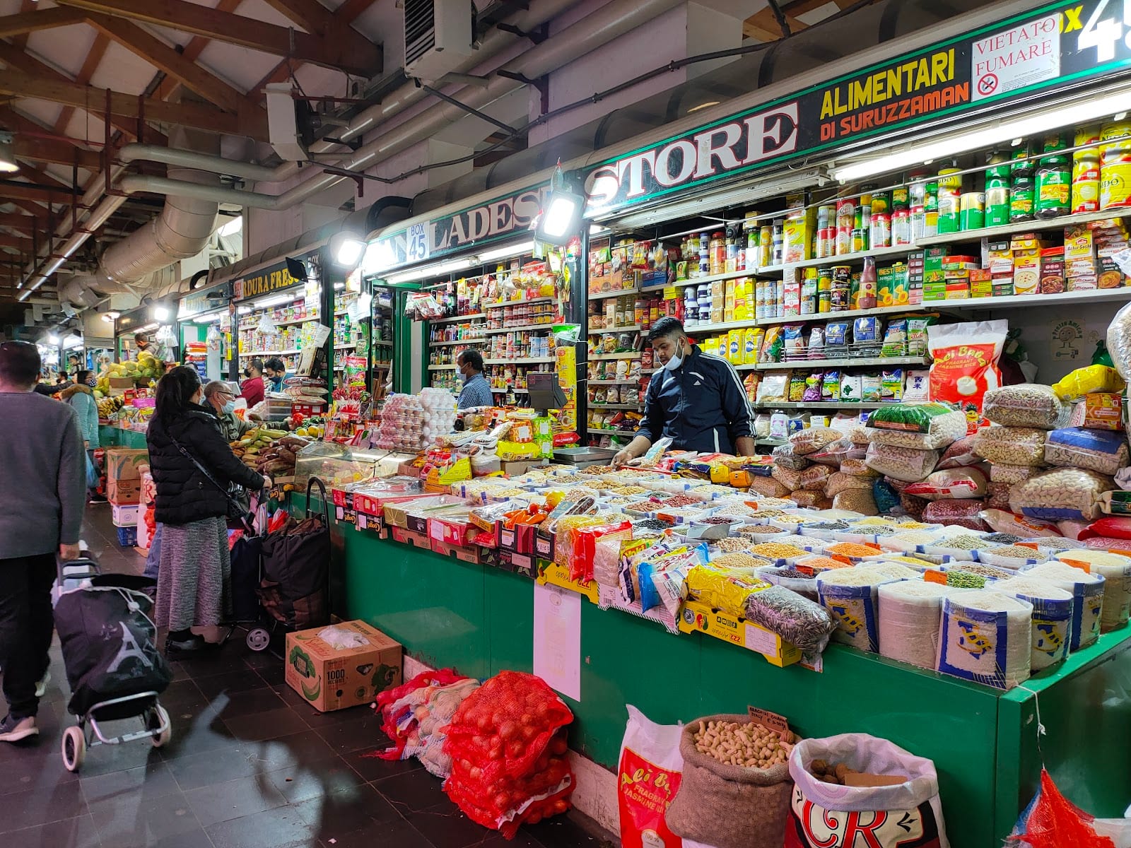 Shoppers at a stall of international groceries and spices in the Nuovo Mercato Esquilino.