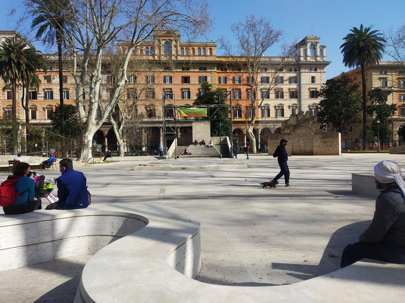 The arcaded, Turin-style porticoed blocks around Piazza Vittorio Emanuele II with people in the square.