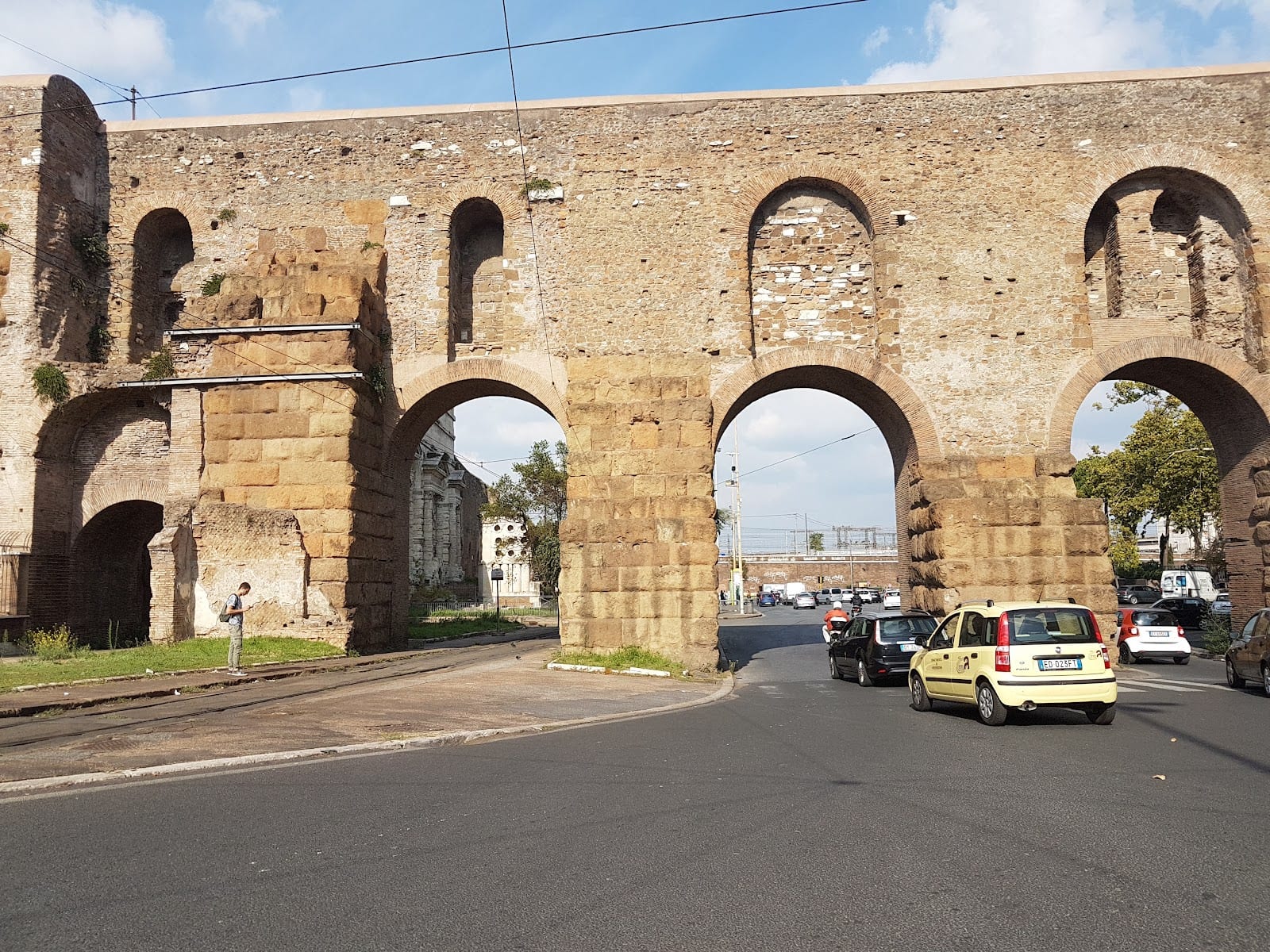 The travertine aqueduct arches of the Porta Maggiore complex.