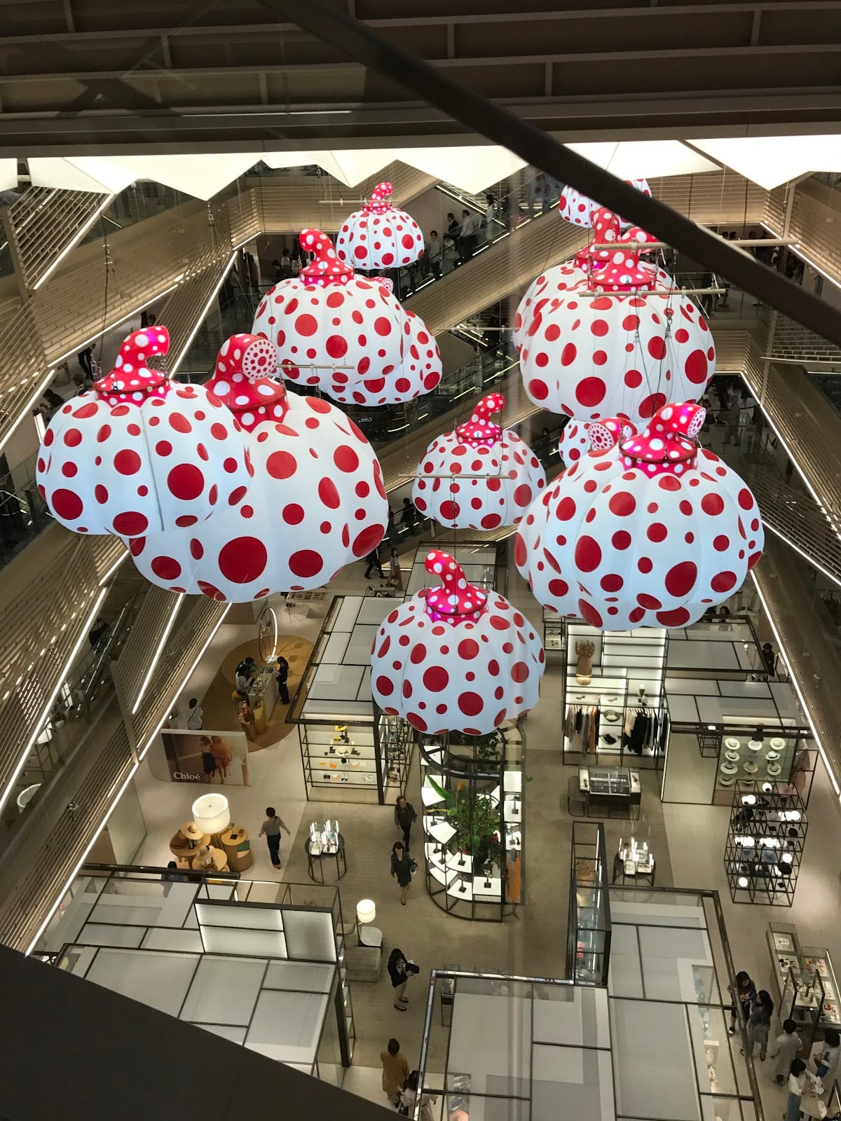 Yayoi Kusama's polka-dot pumpkins suspended in the Ginza Six atrium.