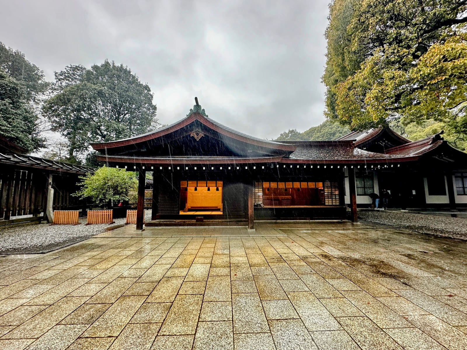 A wooden shrine hall at Meiji Jingu under a cloudy sky.