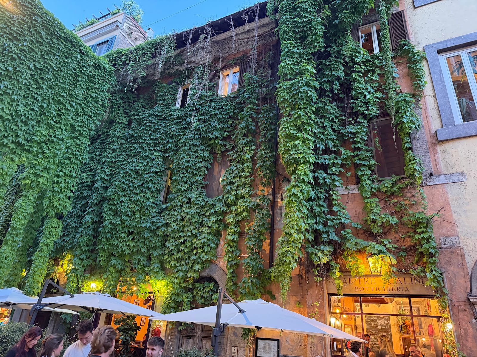 The ivy-covered exterior of Ai Tre Scalini with pavement tables.