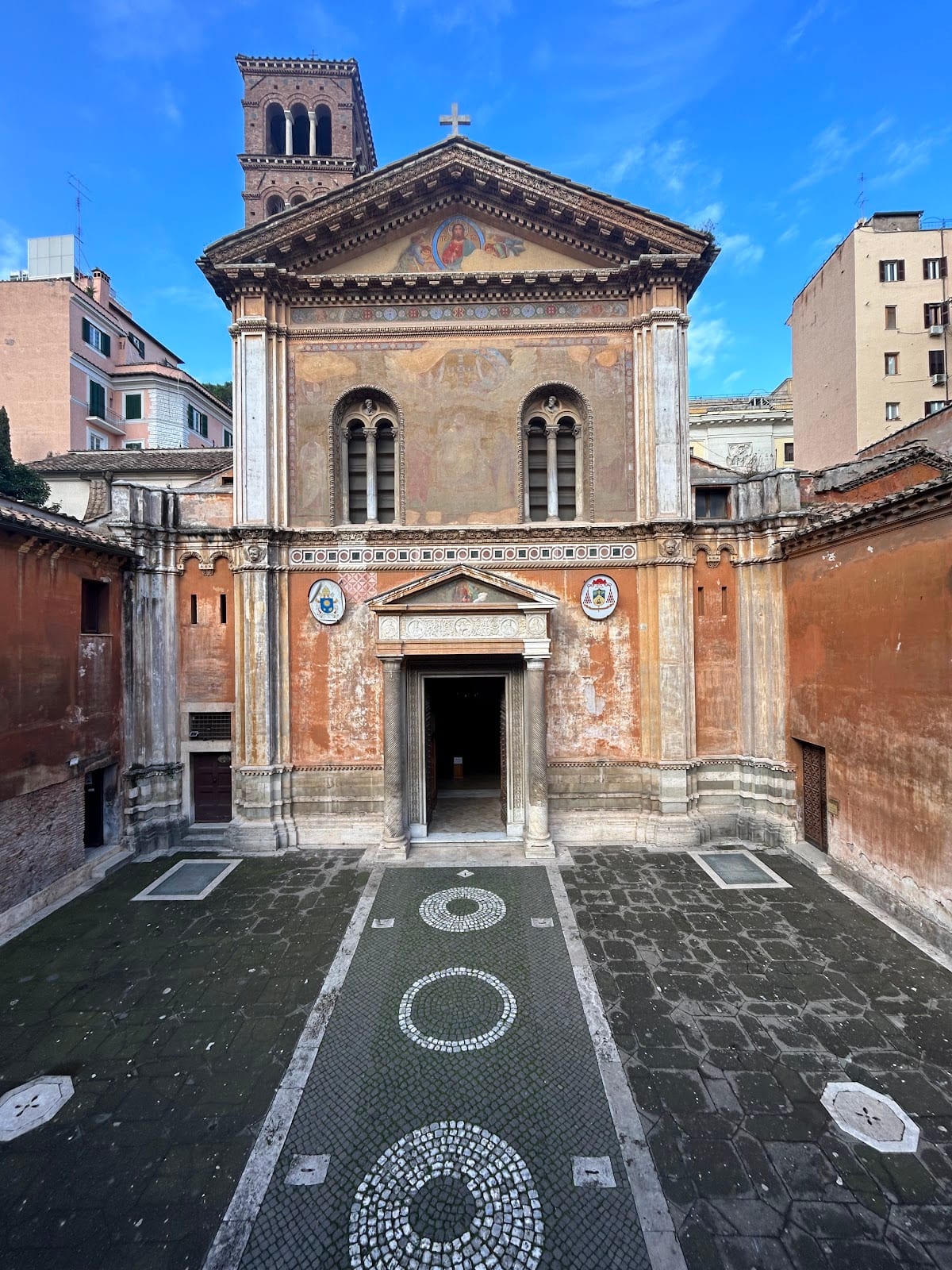 The sunken brick facade and forecourt of Santa Pudenziana on Via Urbana.