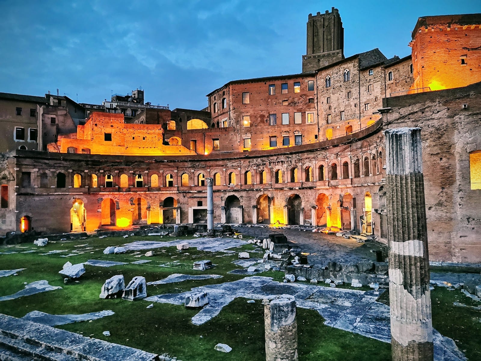 Trajan's Market lit against a blue dusk sky.