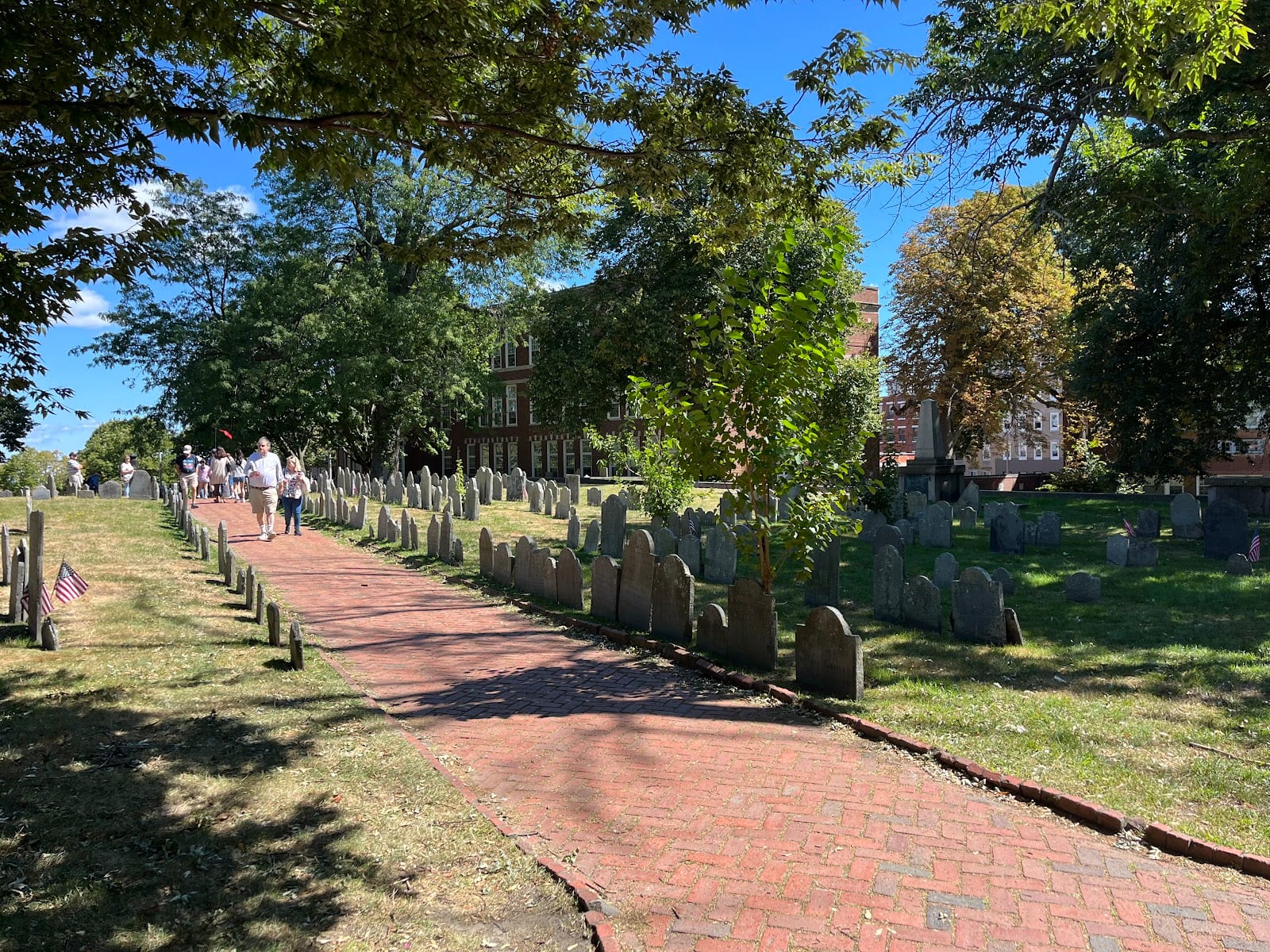 Historic headstones at Copp's Hill Burying Ground with Boston Harbor behind.