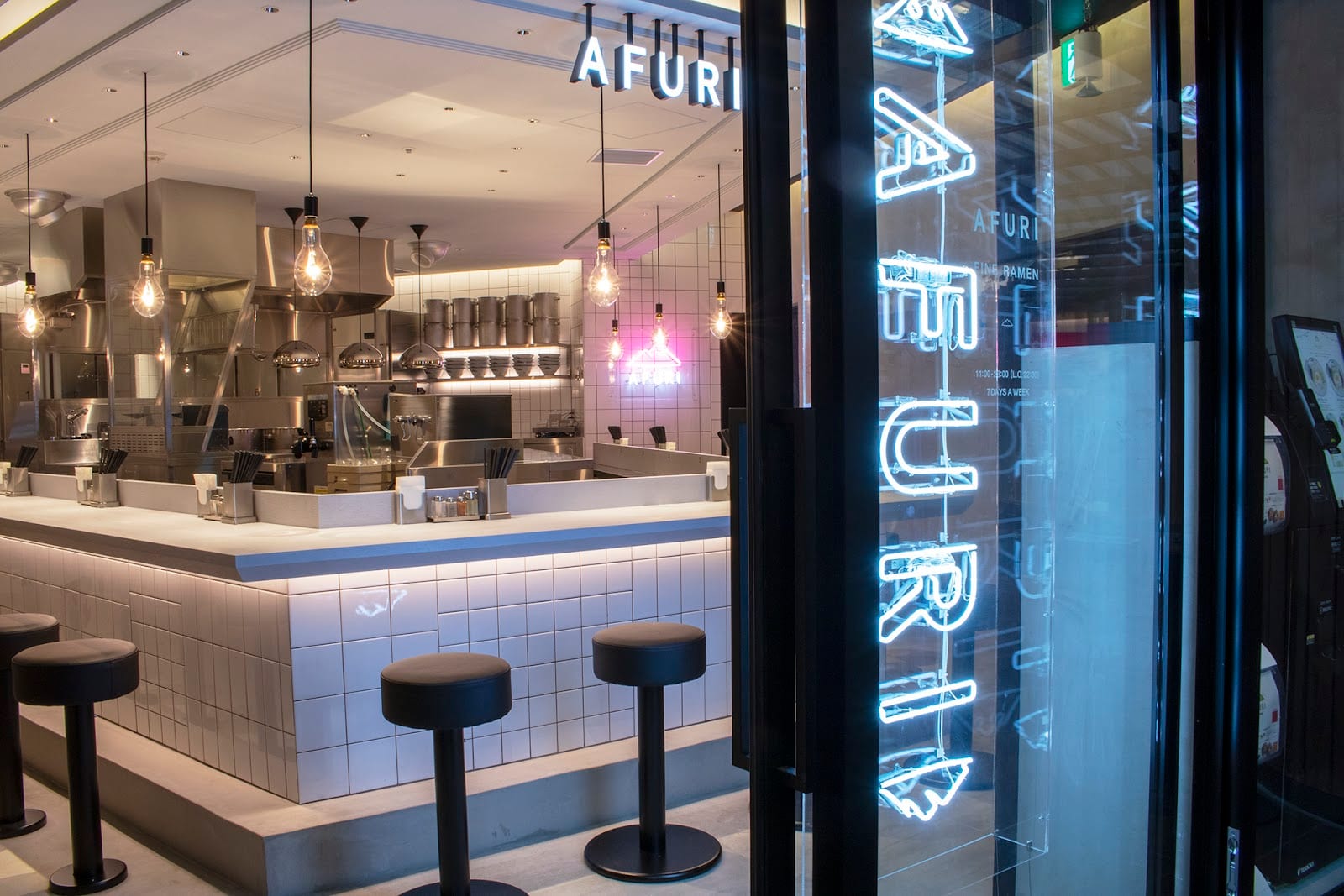 The modern counter and neon sign of Afuri Roppongi.