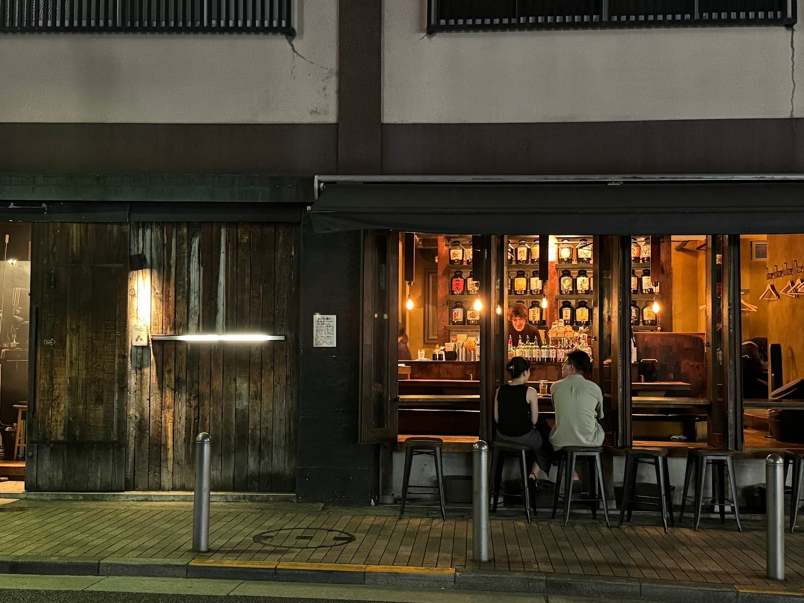 The dark wooden storefront of Jomon Roppongi at night.
