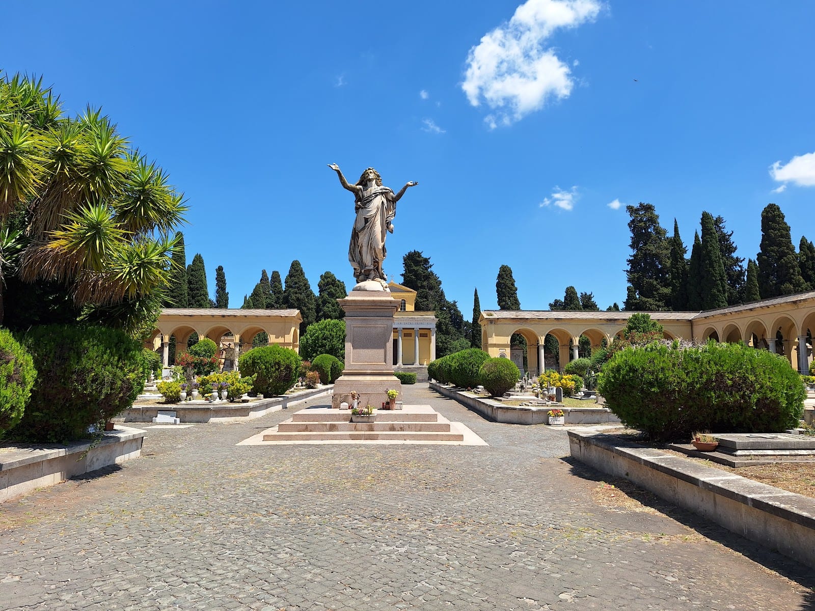 The central statue and cypress avenues of the Verano monumental cemetery in Rome.