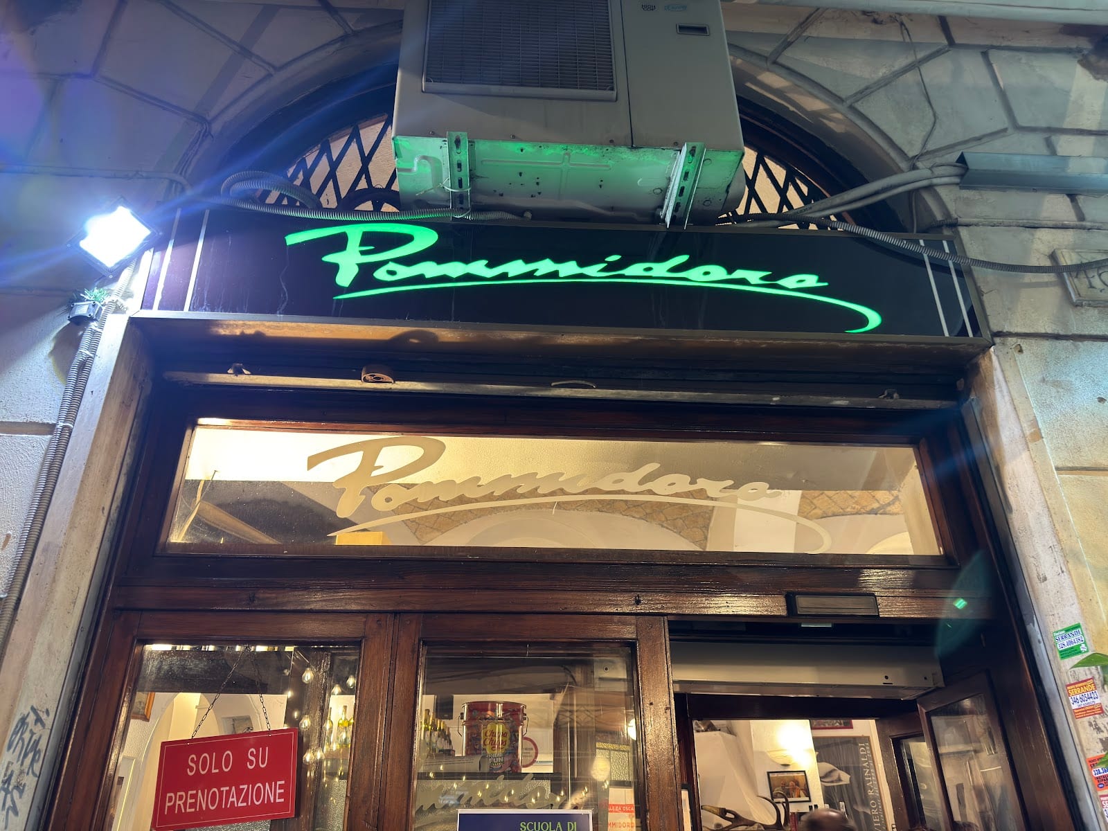 The green neon storefront of the historic Pommidoro trattoria in San Lorenzo.