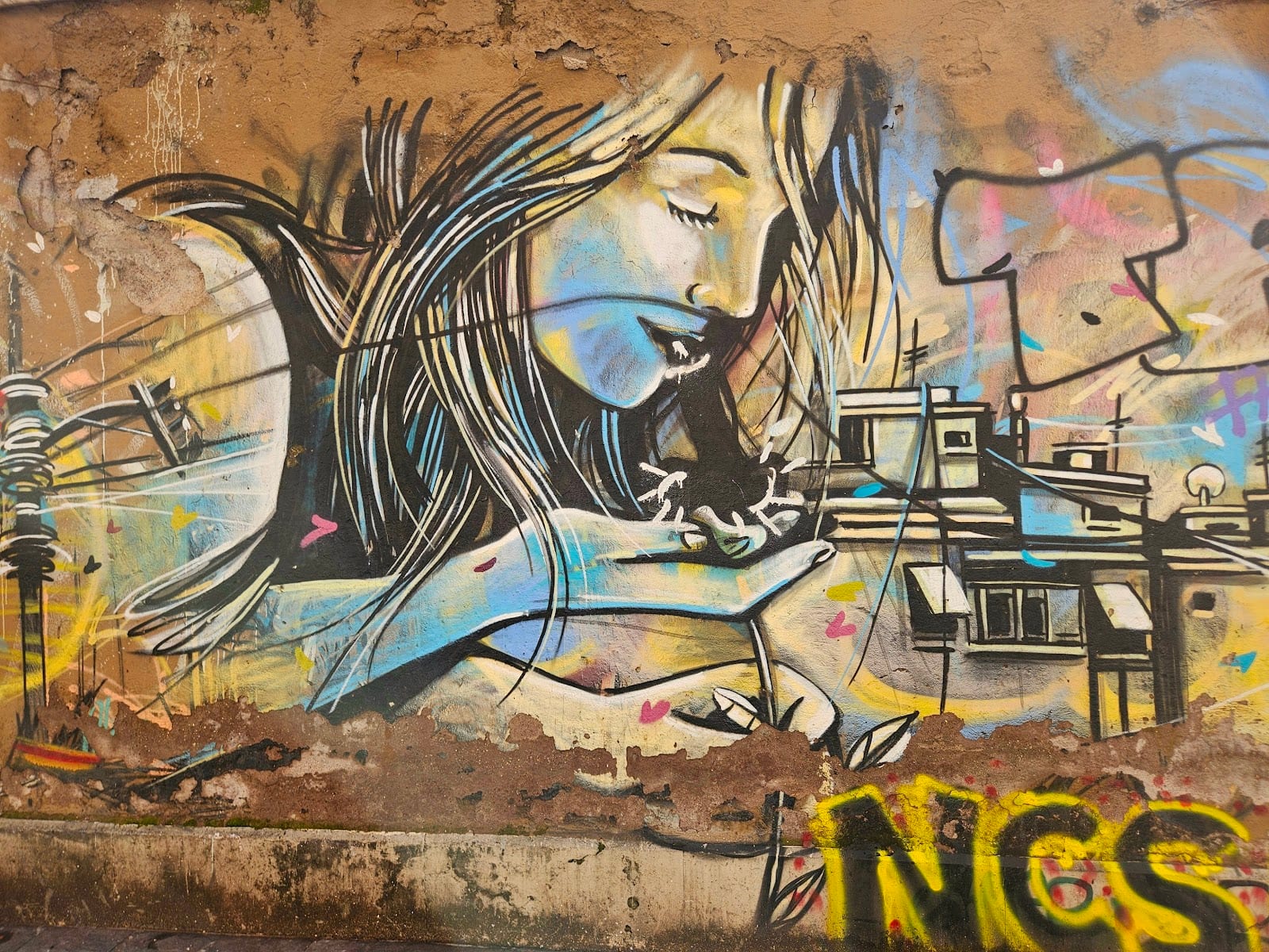 A mural of a woman with flowing hair over a cityscape in San Lorenzo, Rome.