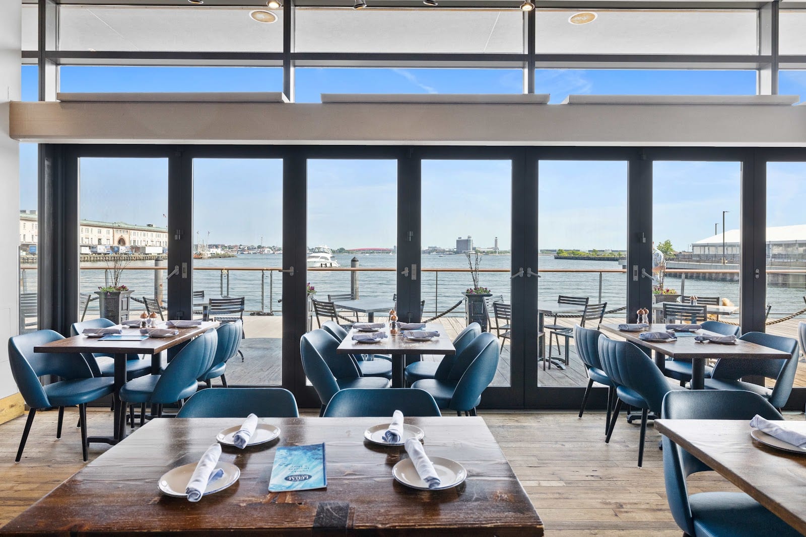 Dining room at Legal Harborside with floor-to-ceiling windows overlooking Boston Harbor.