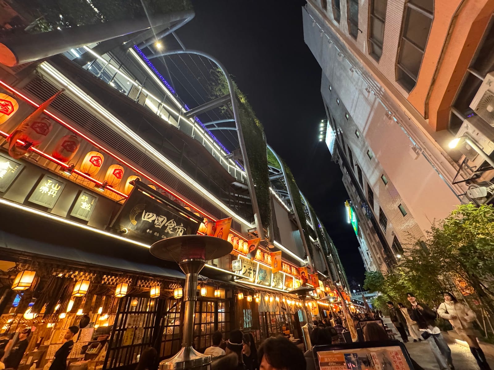 The narrow lantern-strung alley of Nonbei Yokocho at night.