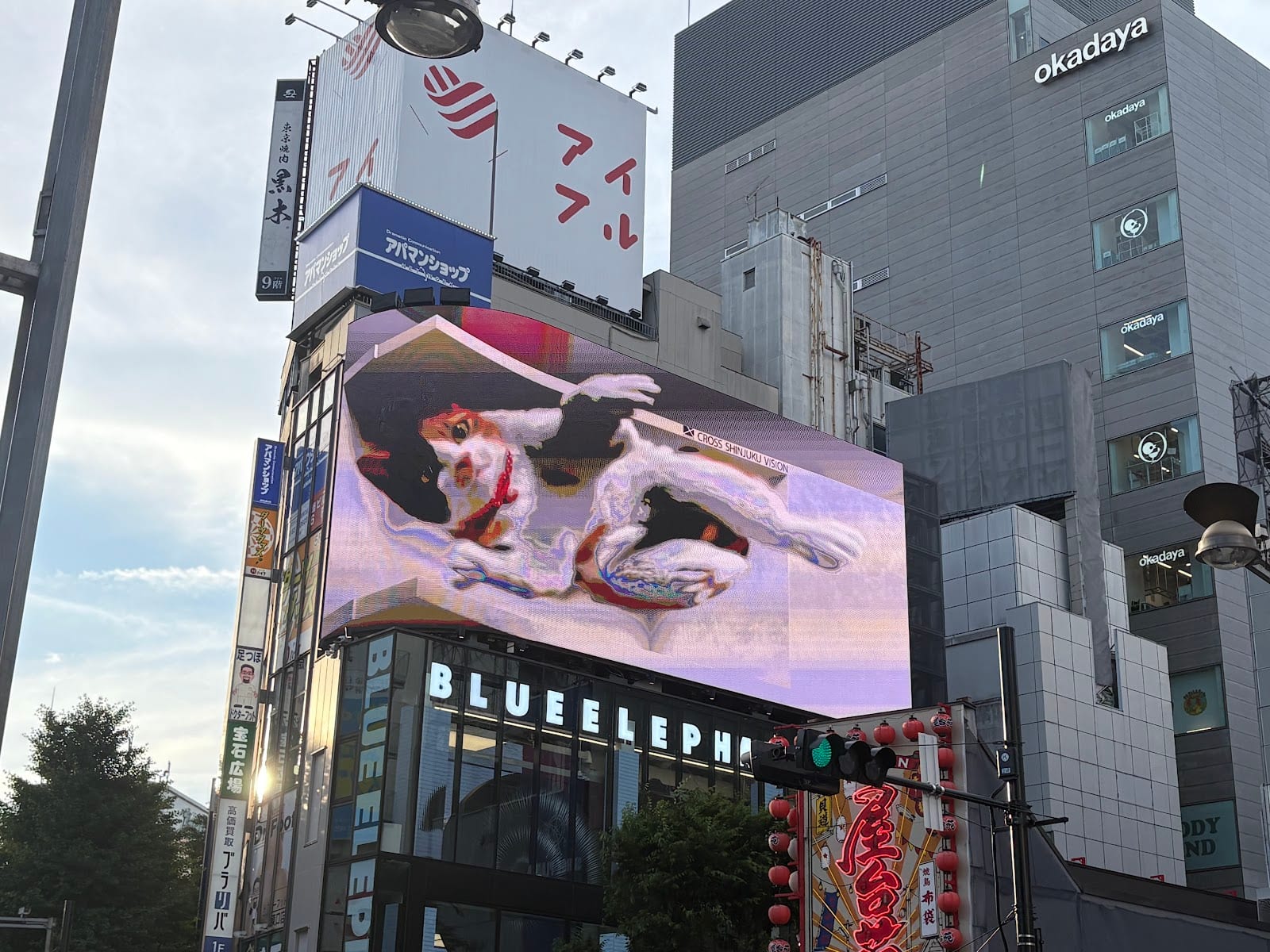 The giant 3D calico cat on the curved Cross Shinjuku Vision screen.