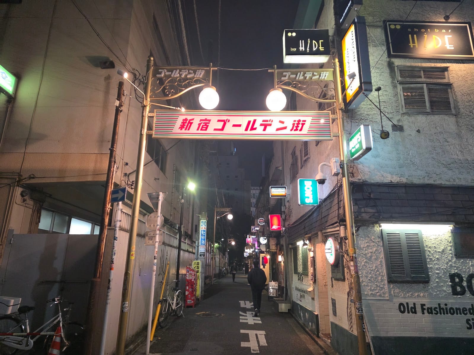 A lane of tiny bars in Shinjuku's Golden Gai beneath its sign.