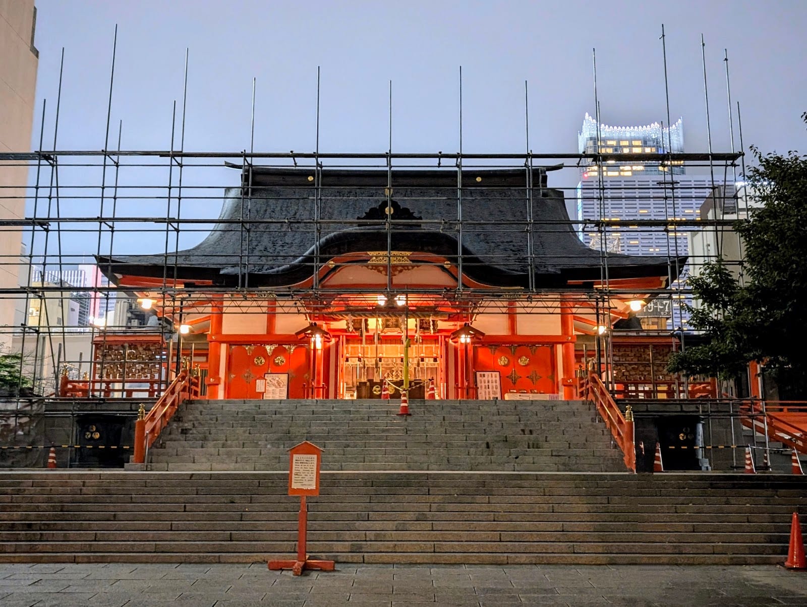 The lit main hall of Hanazono Shrine at dusk.