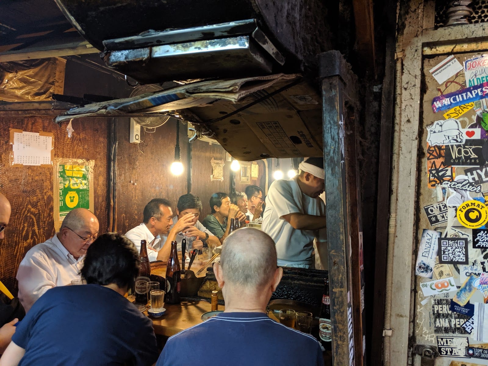 Diners at a tiny counter eatery in Omoide Yokocho.