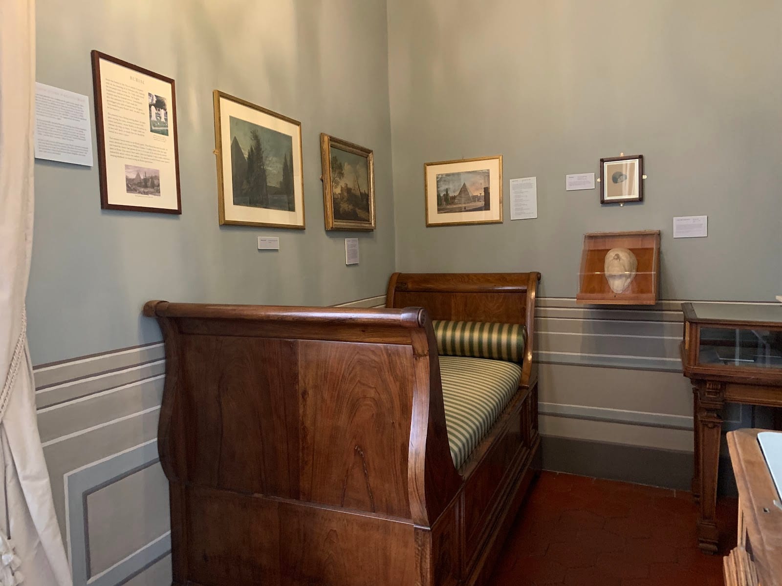 A museum room of prints and a period bed inside the Keats-Shelley House.