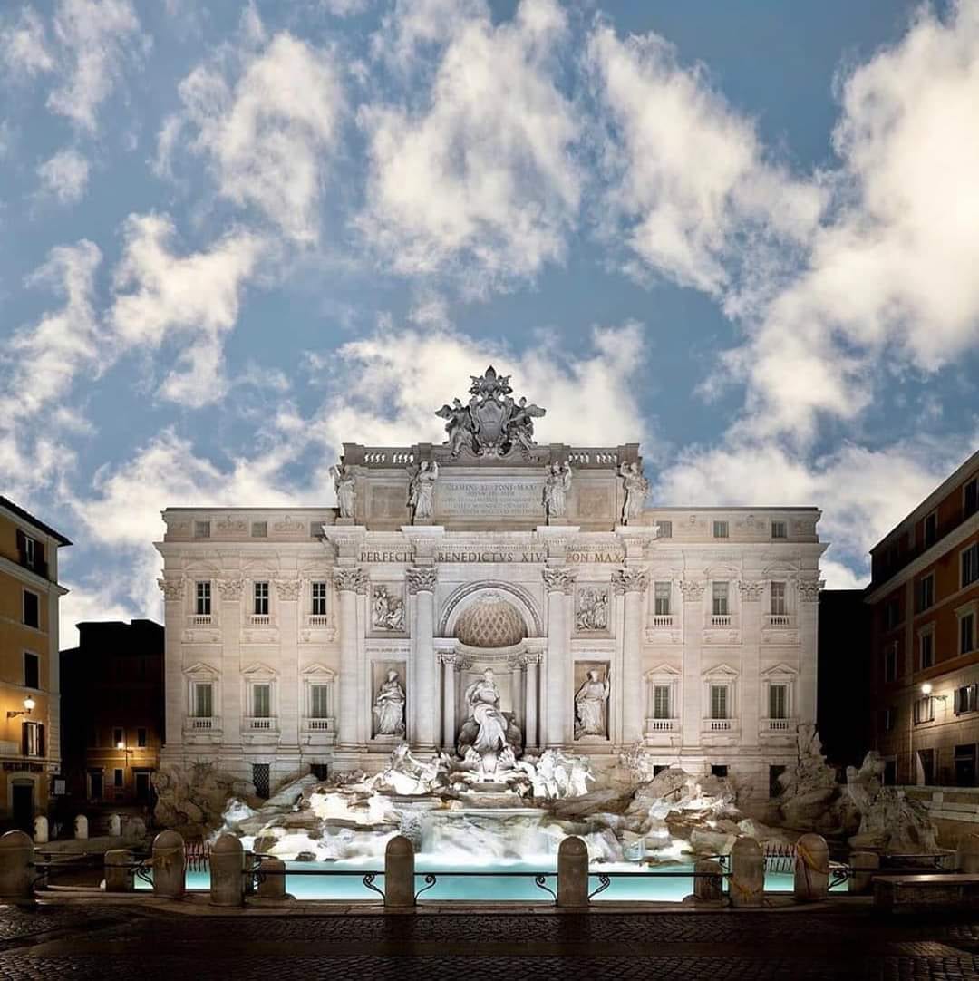 The Trevi Fountain lit at dusk.