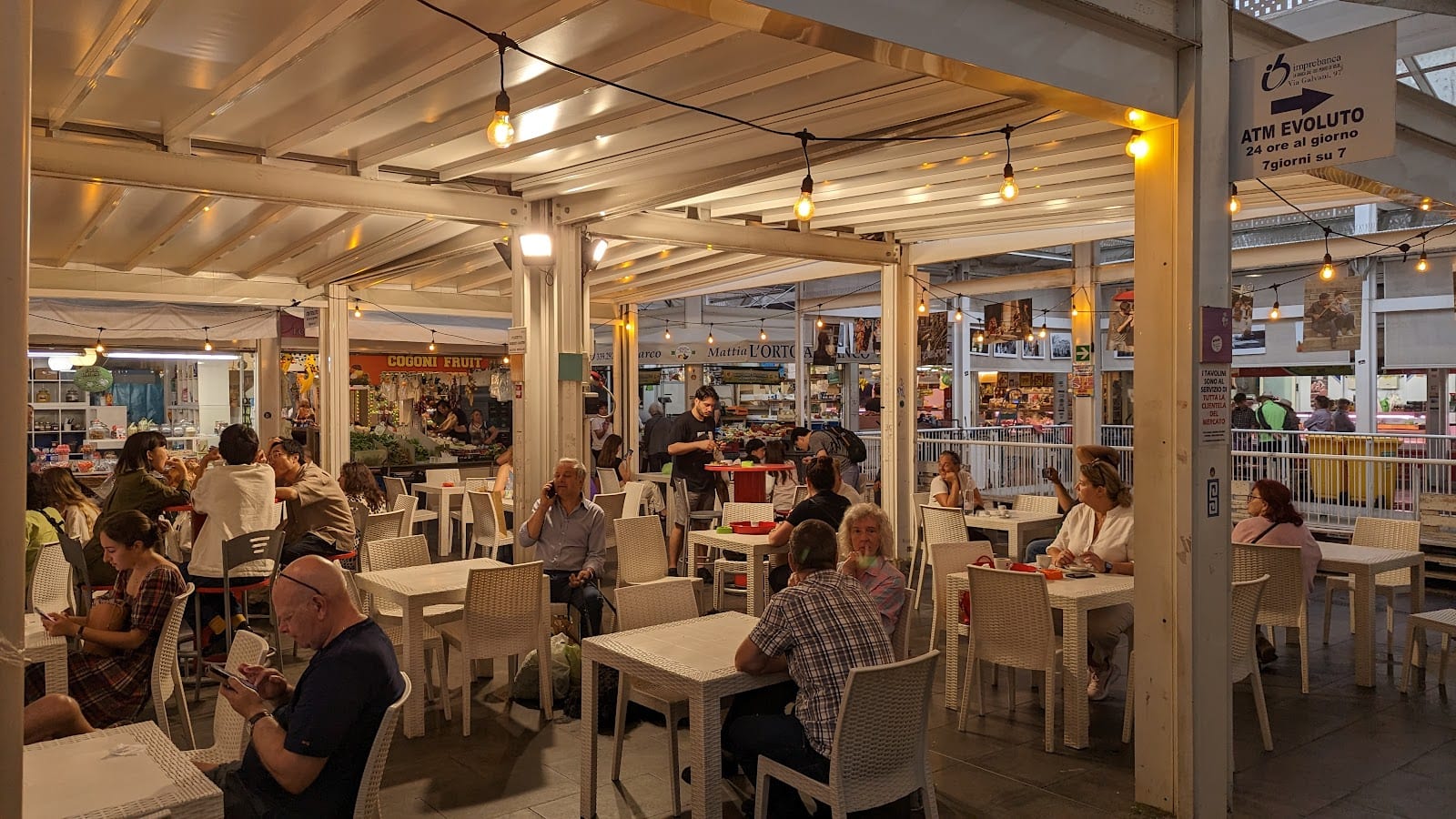 Diners at tables in the covered food hall of the Testaccio market.
