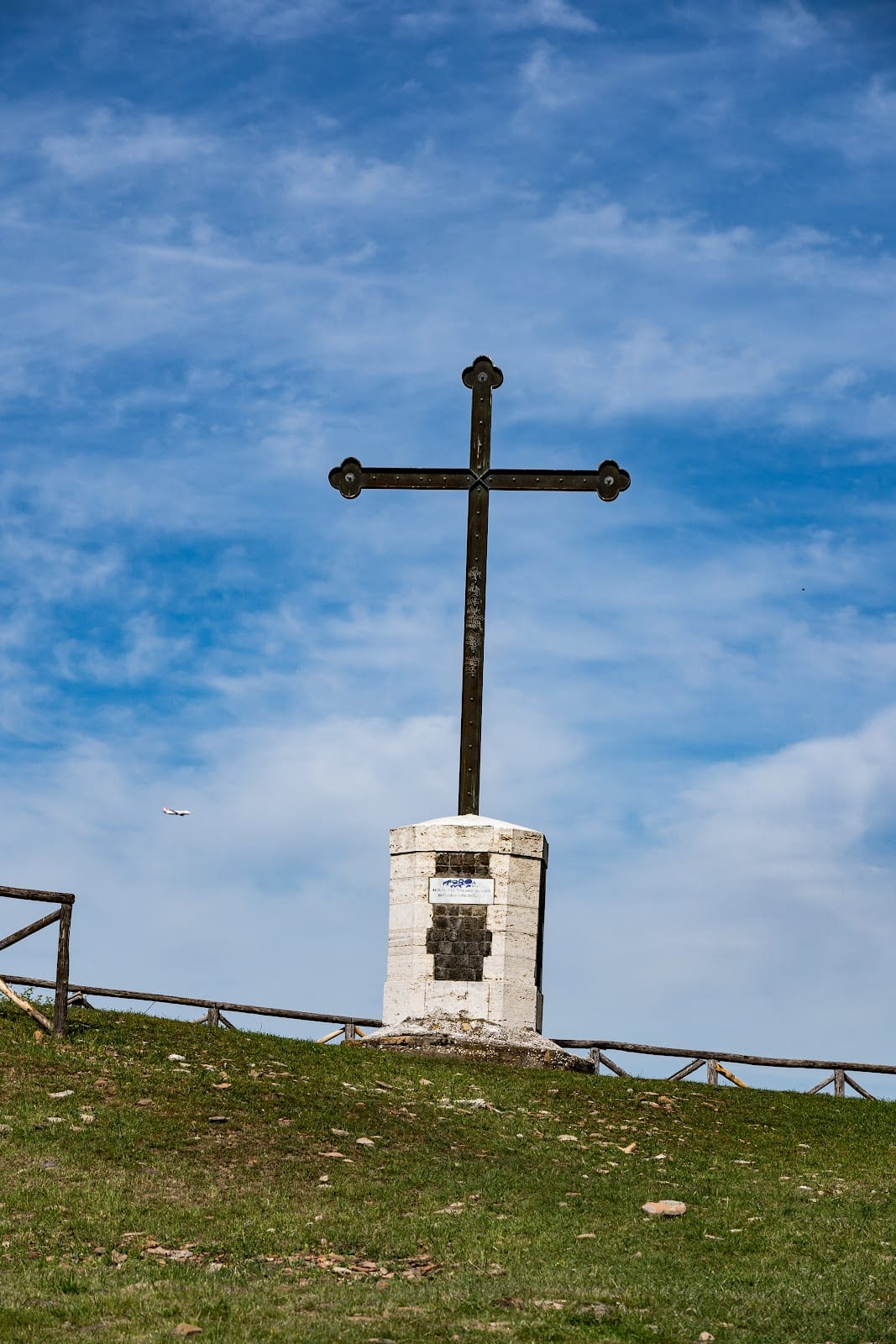 The cross at the summit of Monte Testaccio against a blue sky.