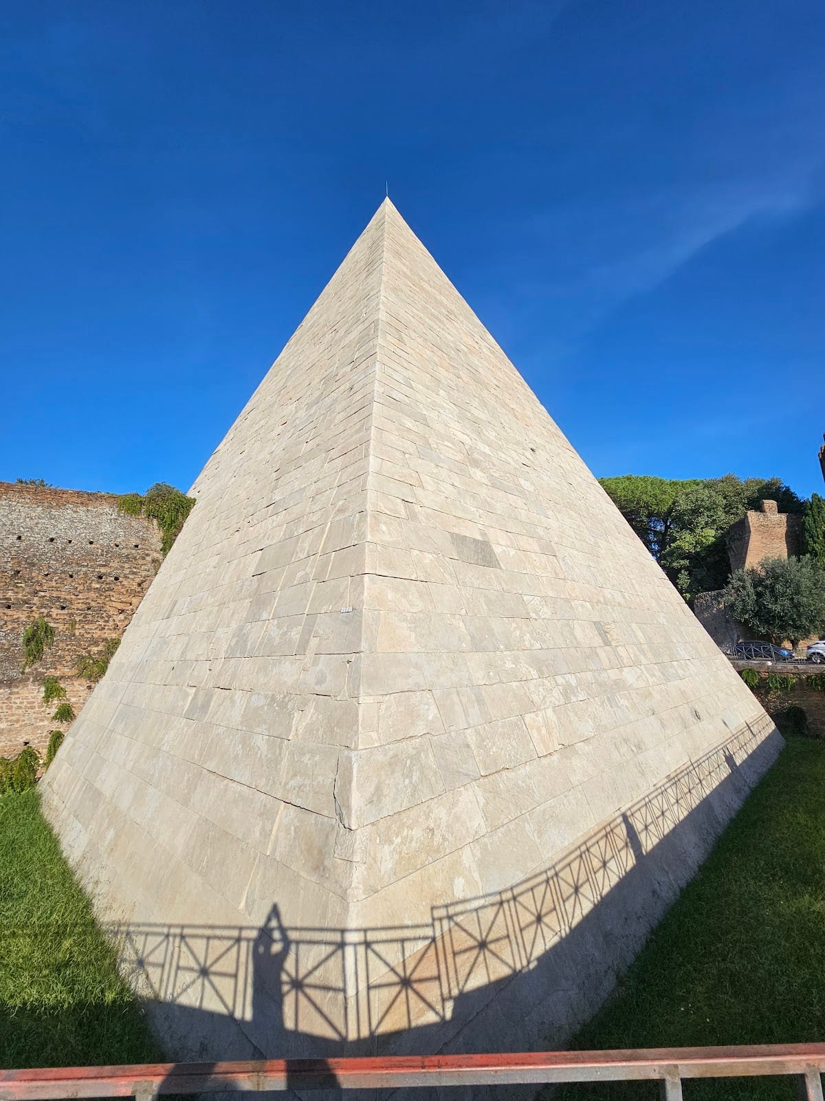 The steep marble apex of the Pyramid of Cestius against the sky.