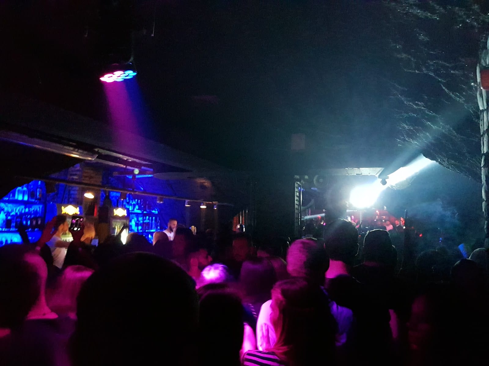 A crowd under colored lights at a club on Via di Monte Testaccio.