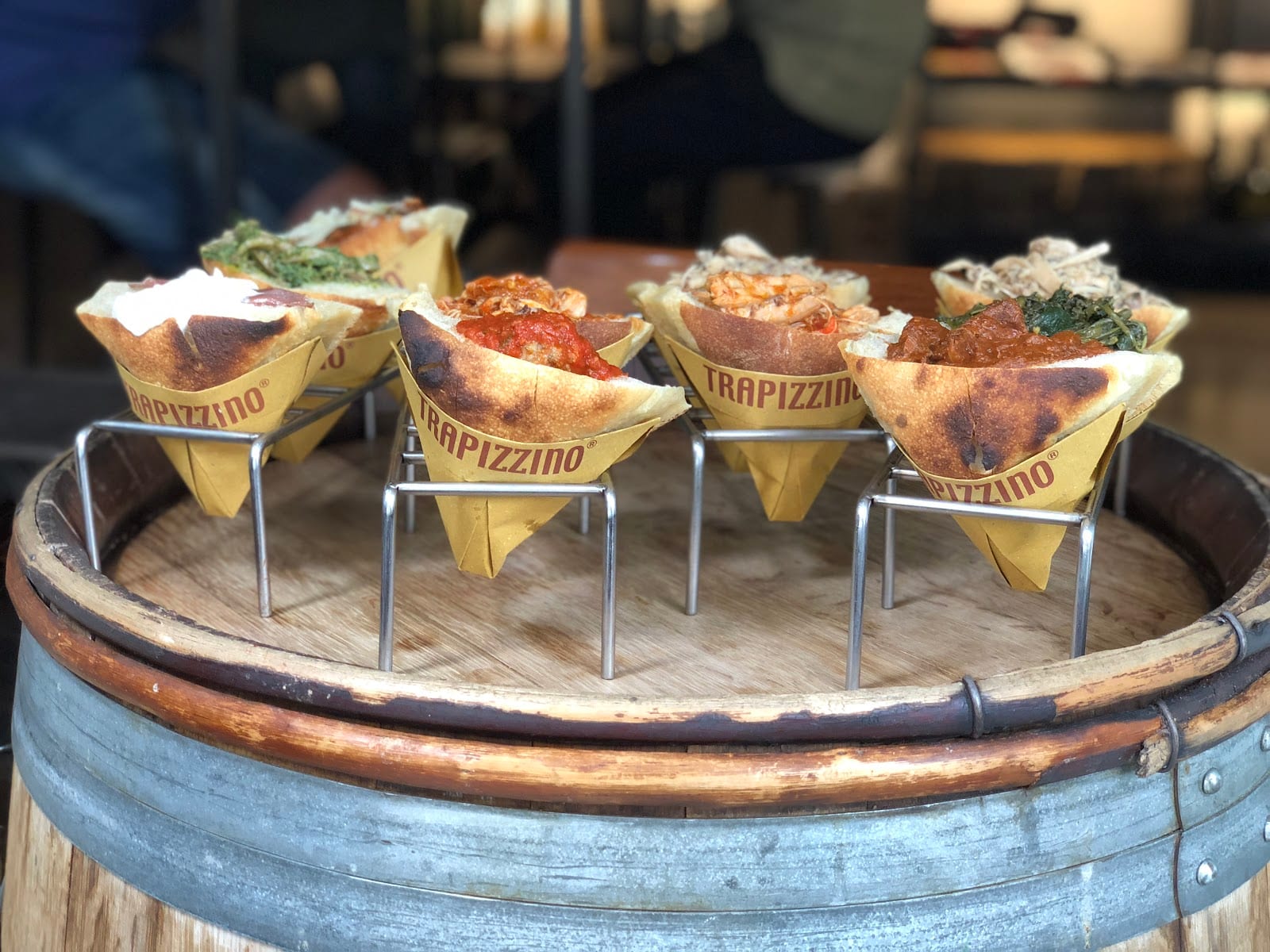 Four trapizzini in paper cones showing their Roman braised fillings.