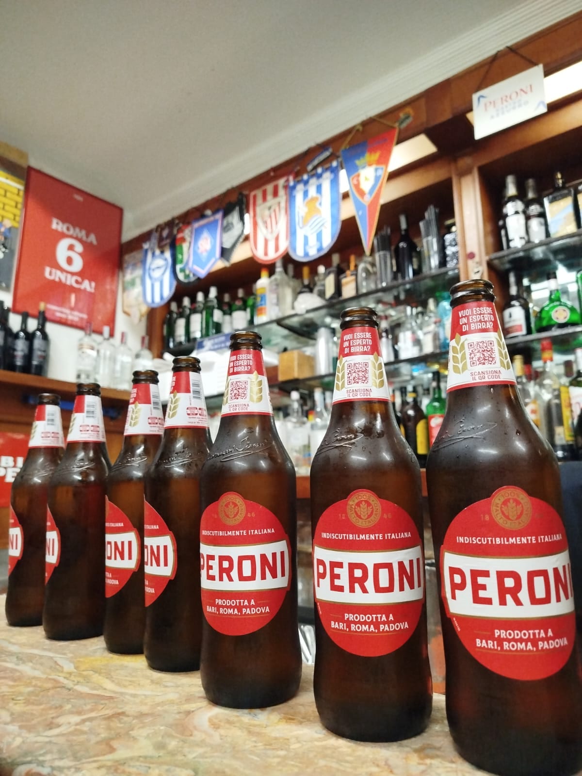 Peroni bottles lined up at the counter of Bar San Calisto.