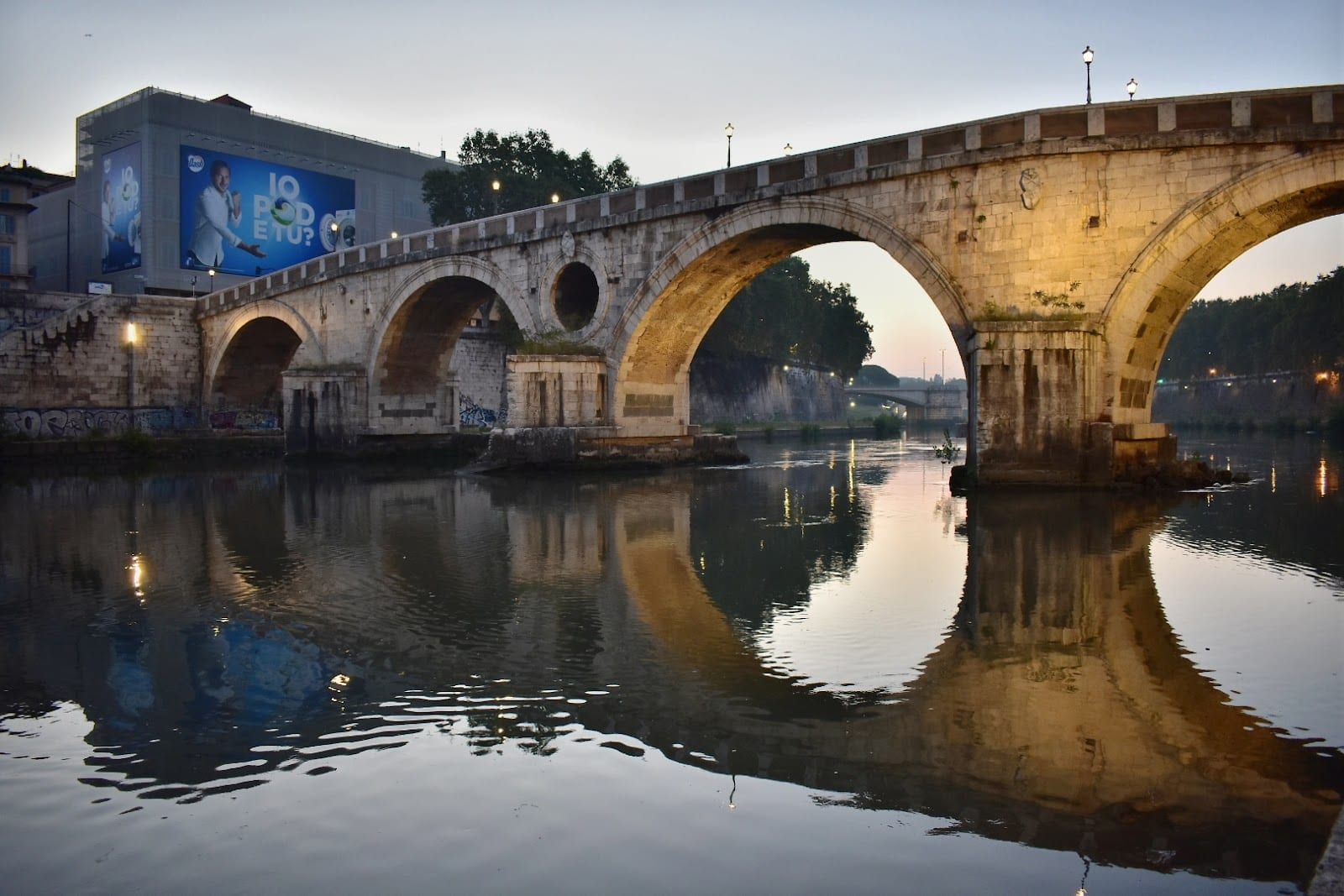 Ponte Sisto and its reflection in the Tiber in soft morning light.