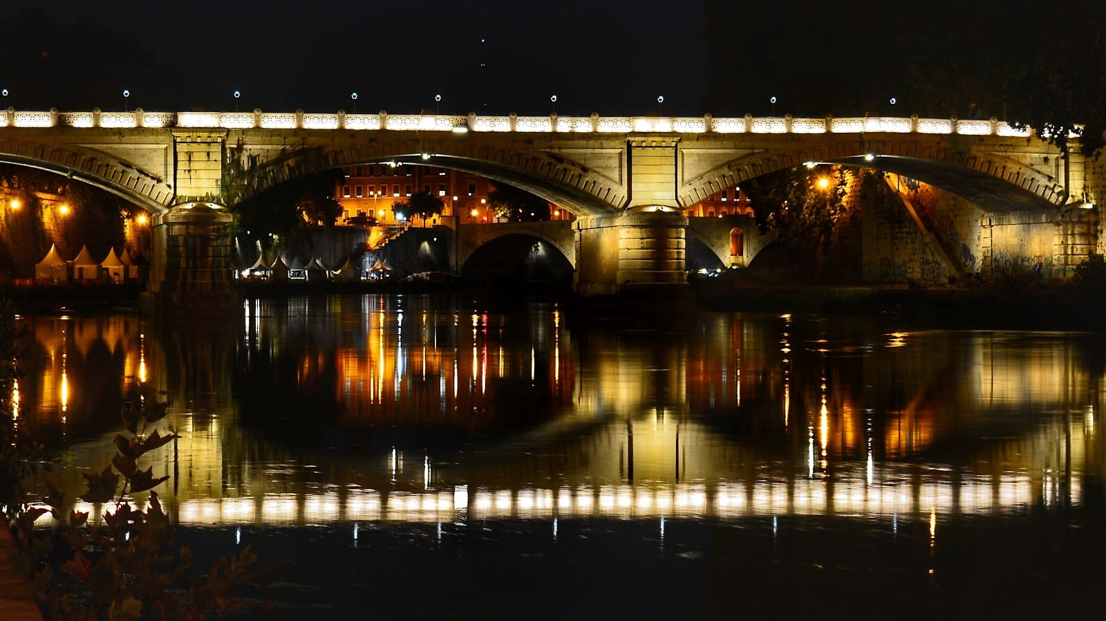 Ponte Sisto lit up over the Tiber at night.