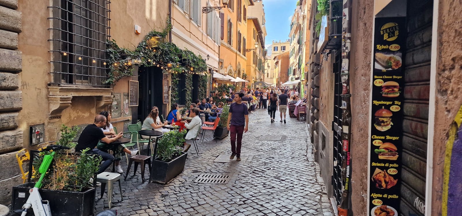 A cobbled, ivy-hung Trastevere lane lined with trattoria tables.
