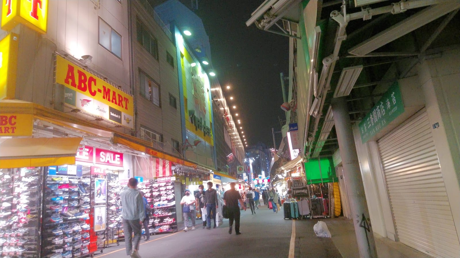 The Ameyoko market street at night, crowded under the elevated train tracks.