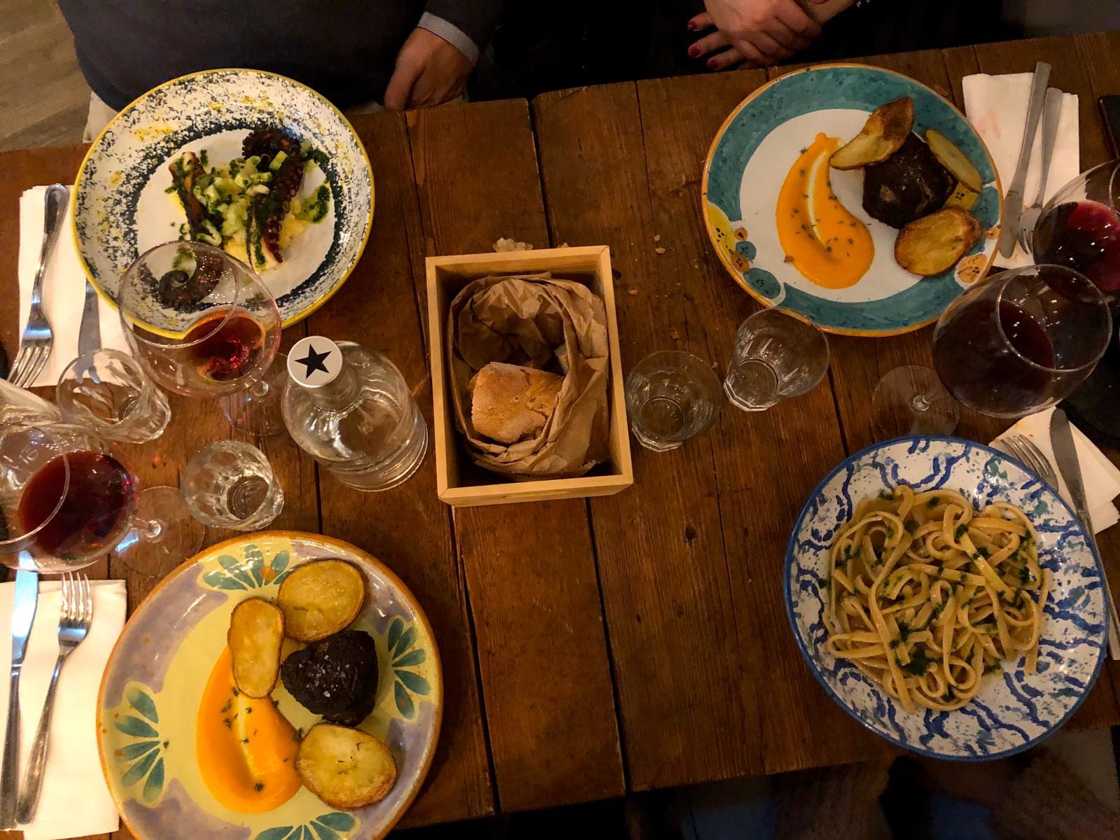 A spread of organic dishes and wine on a wooden table at Fa-Bio (reLab).