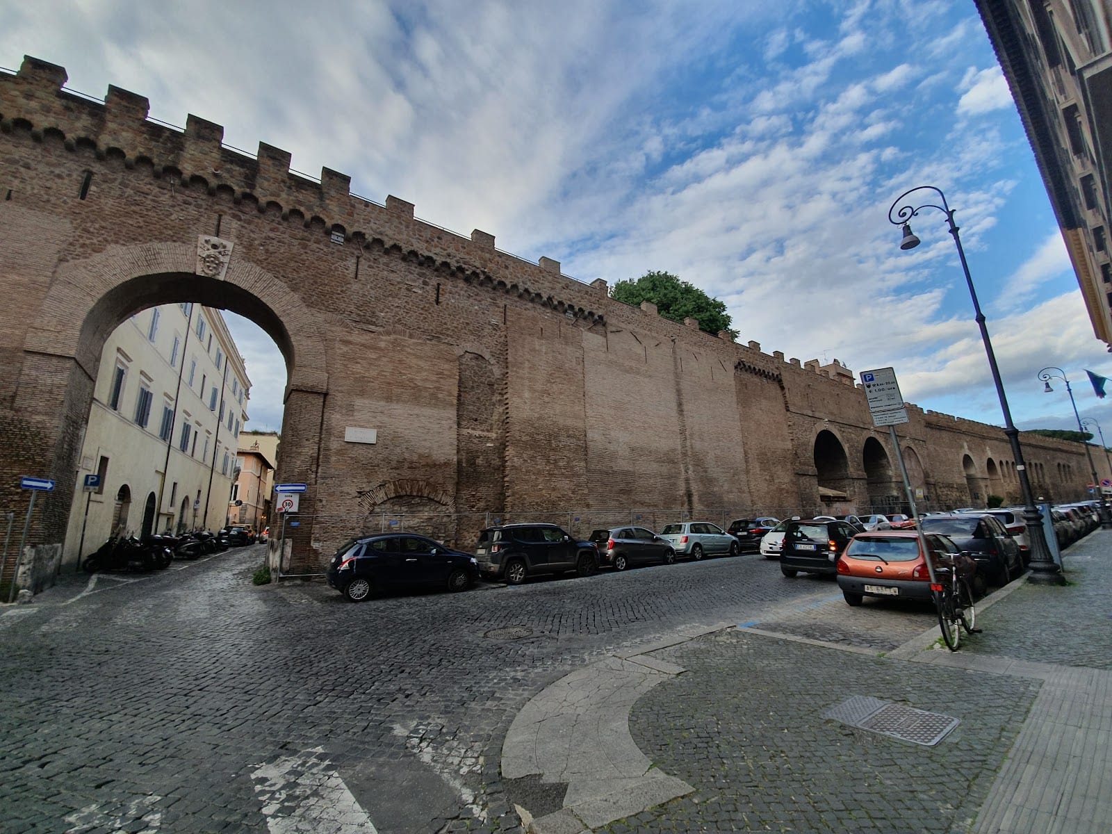 An arched gateway through the brick wall carrying the Passetto di Borgo.