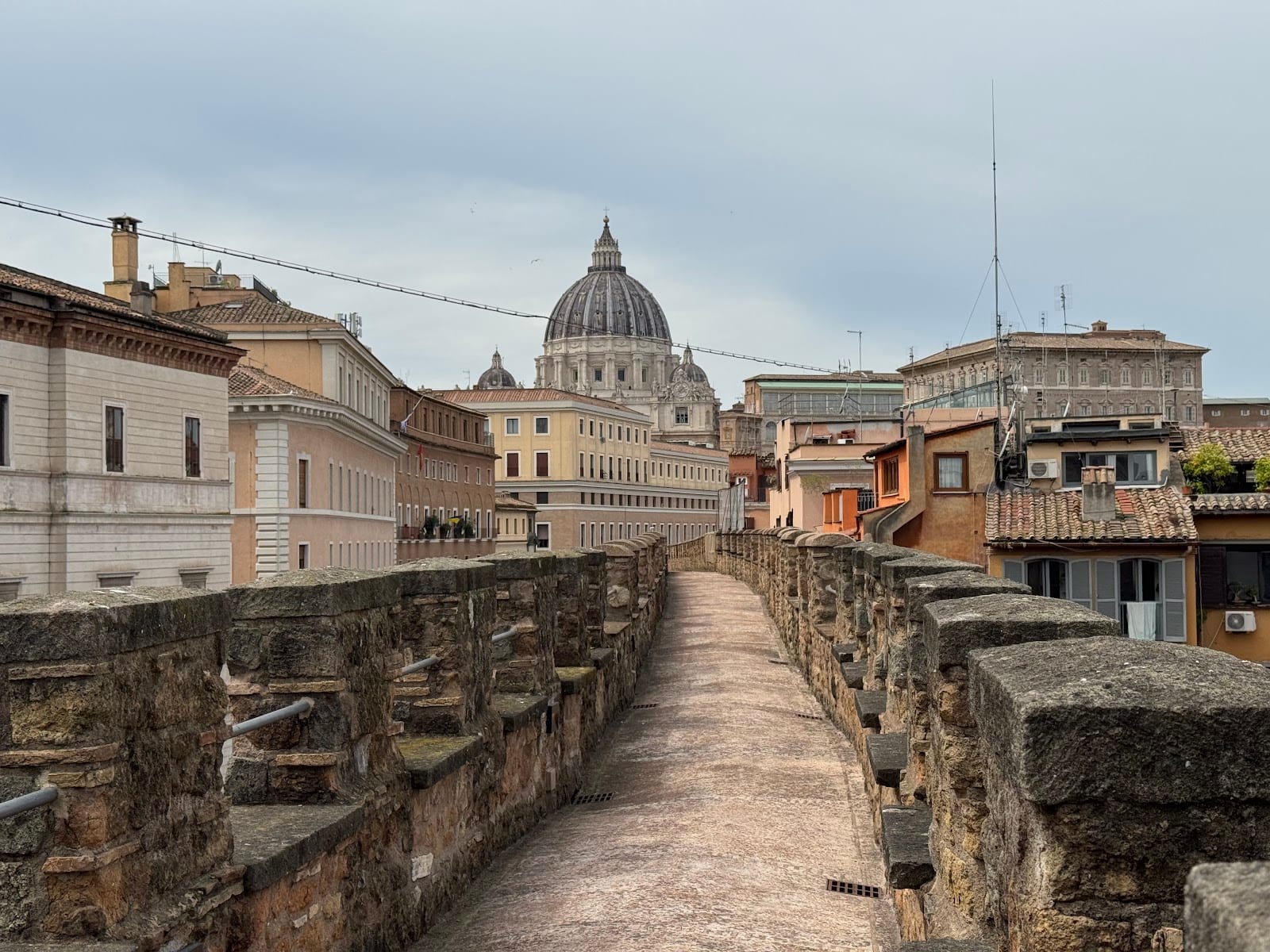 Walking along the elevated Passetto di Borgo corridor with St Peter's dome ahead.