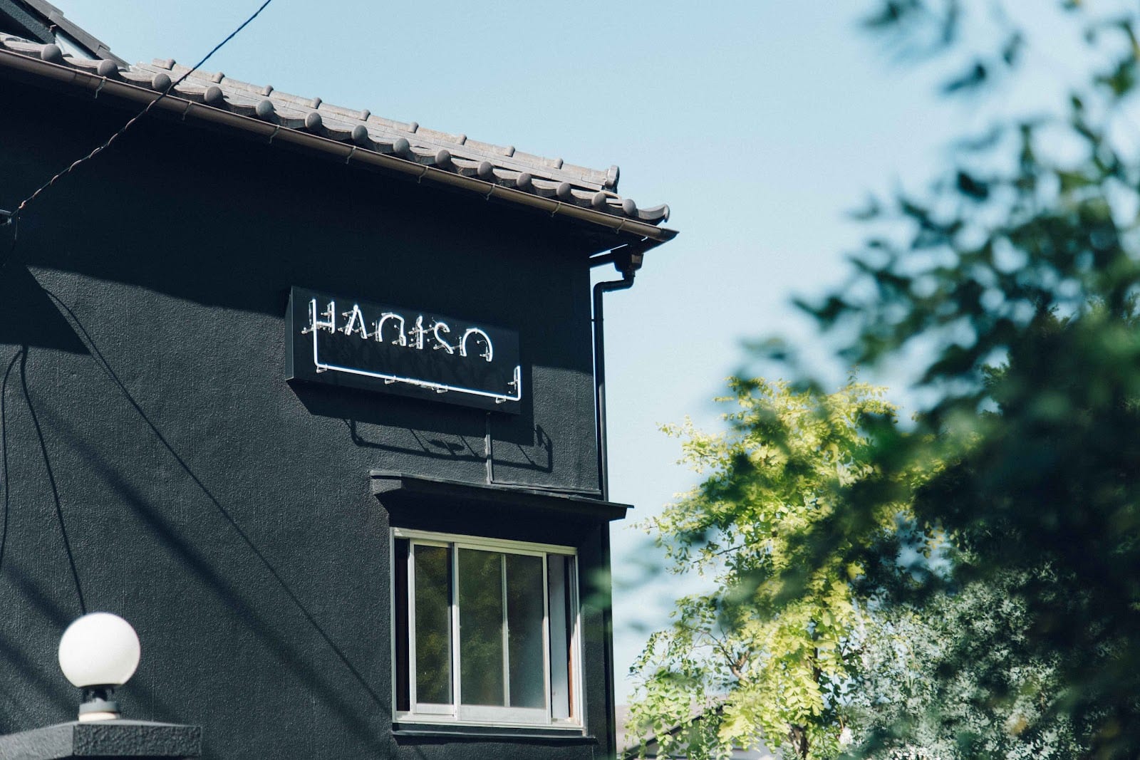 The black-painted facade and sign of HAGISO in Yanaka.