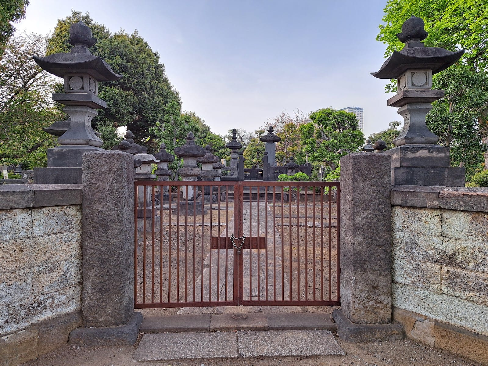 A gated stone grave enclosure in Yanaka Cemetery.